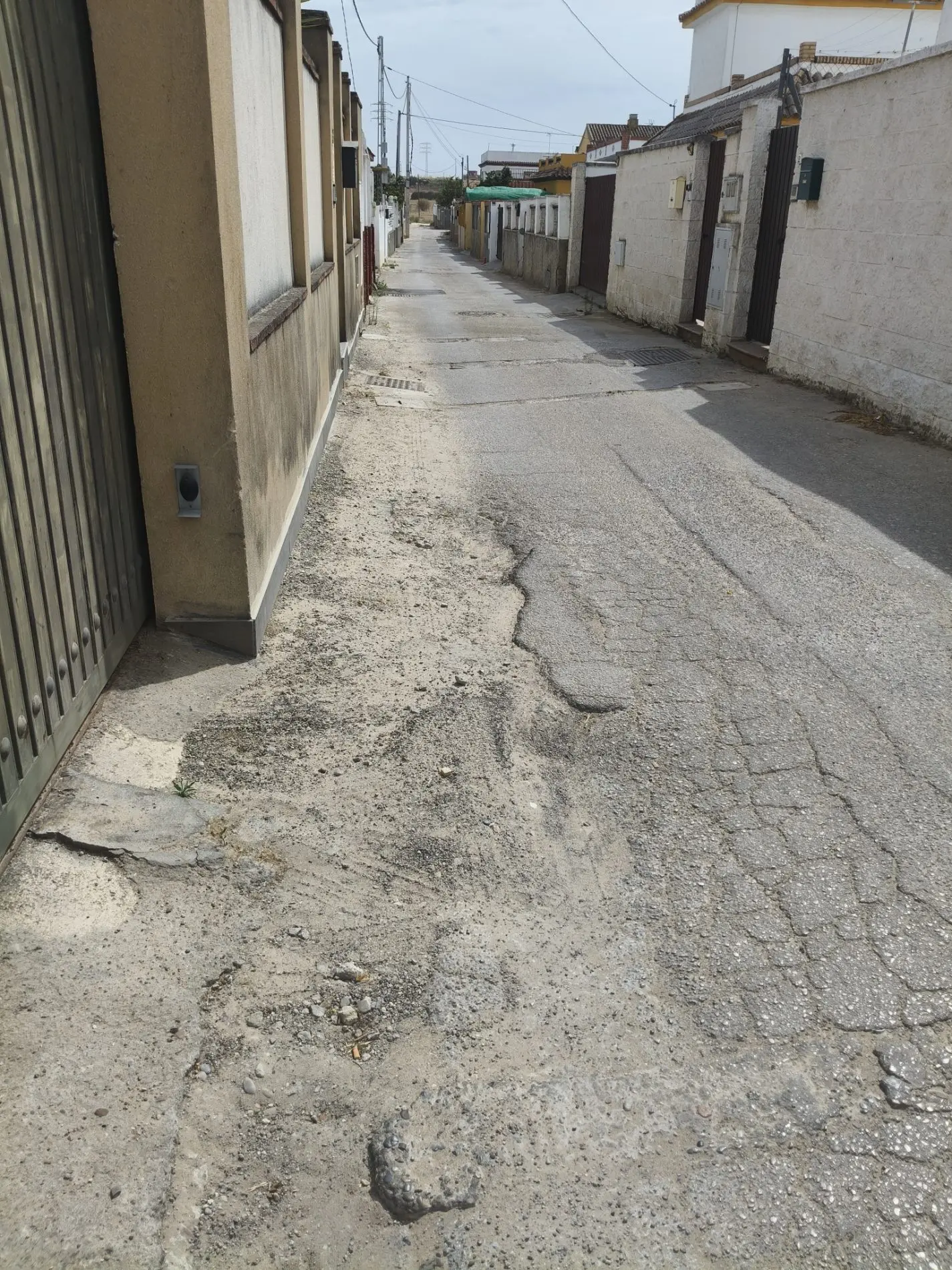 Fotografía de la incidencia: Asfaltado de calle en mal estado. Lleno de agujeros, no hay iluminación, sin acerado