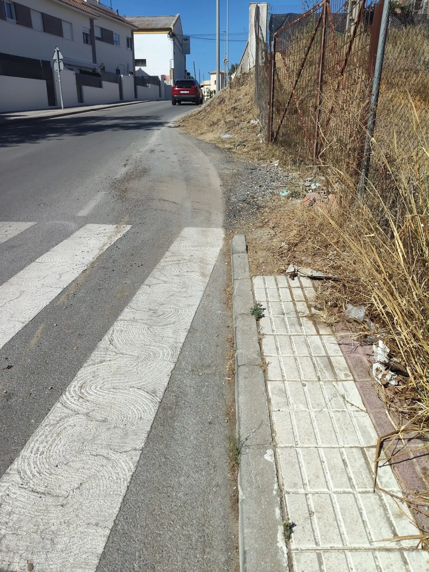Fotografía de la incidencia: No existe acera y el pequeño tramo que existe está totalmente descuidado/destruido/abando…